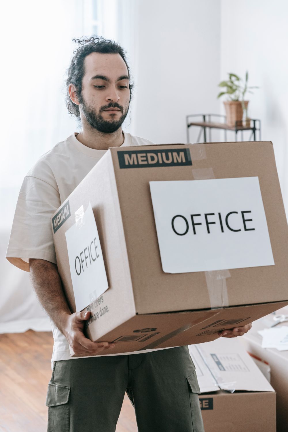 Ofis taşıma sırasında etiketli koli taşıyan çalışan